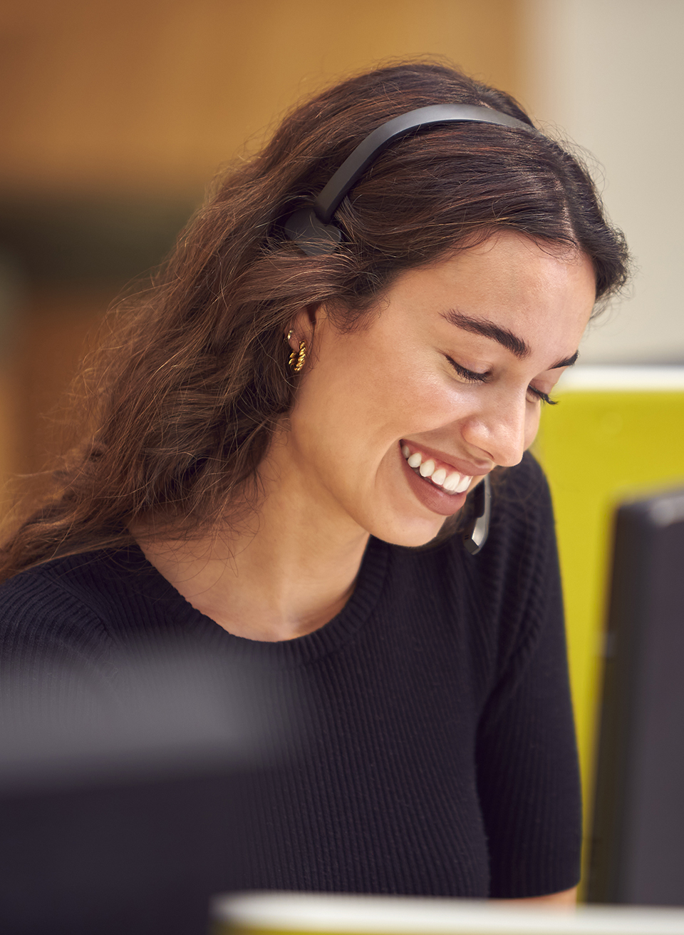 Businesswoman In Cubicle Wearing Headset Talking To Caller In Bu
